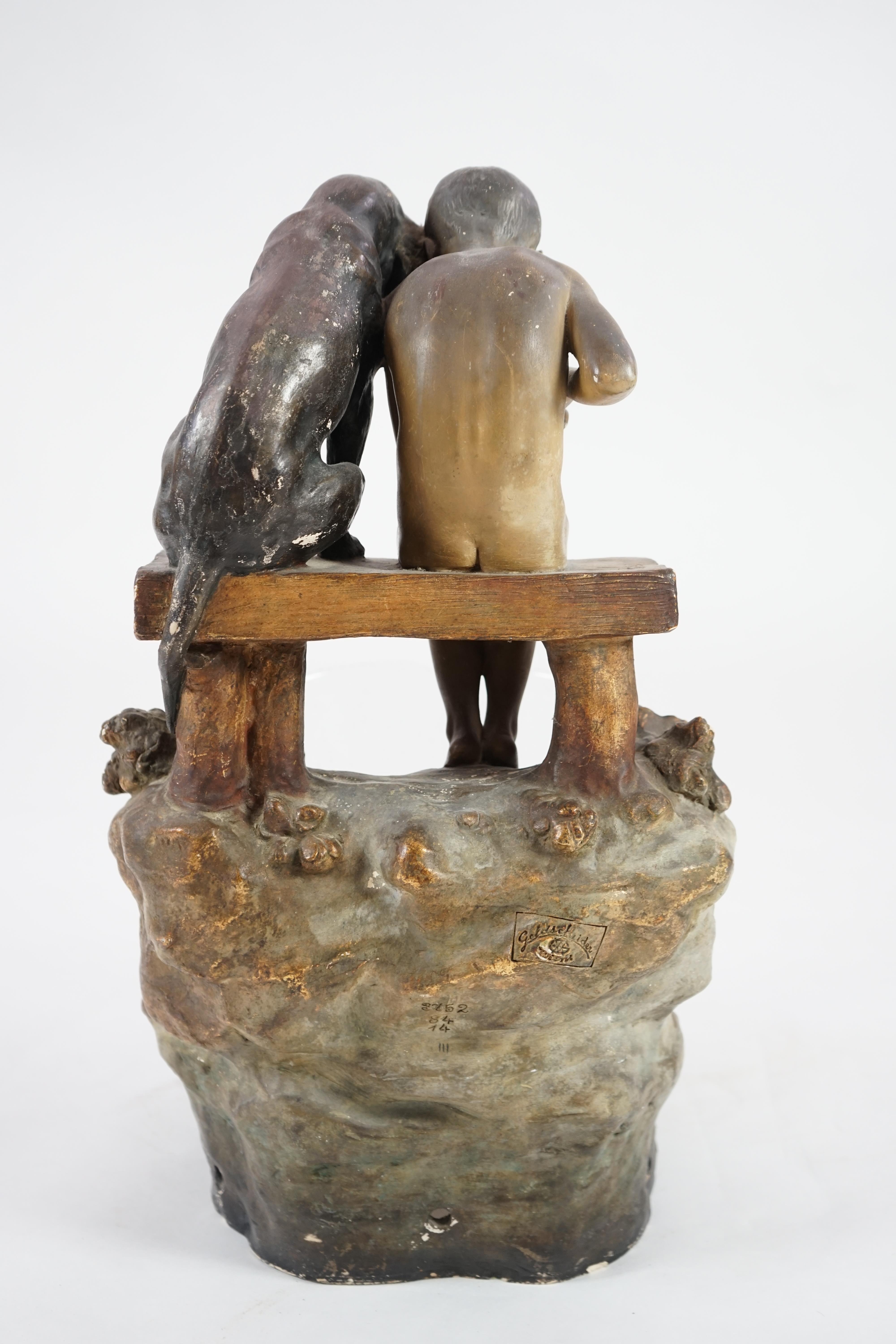 A Goldscheider group of a boy and a dog looking into a pool. Condition - fair, glass bowl not original